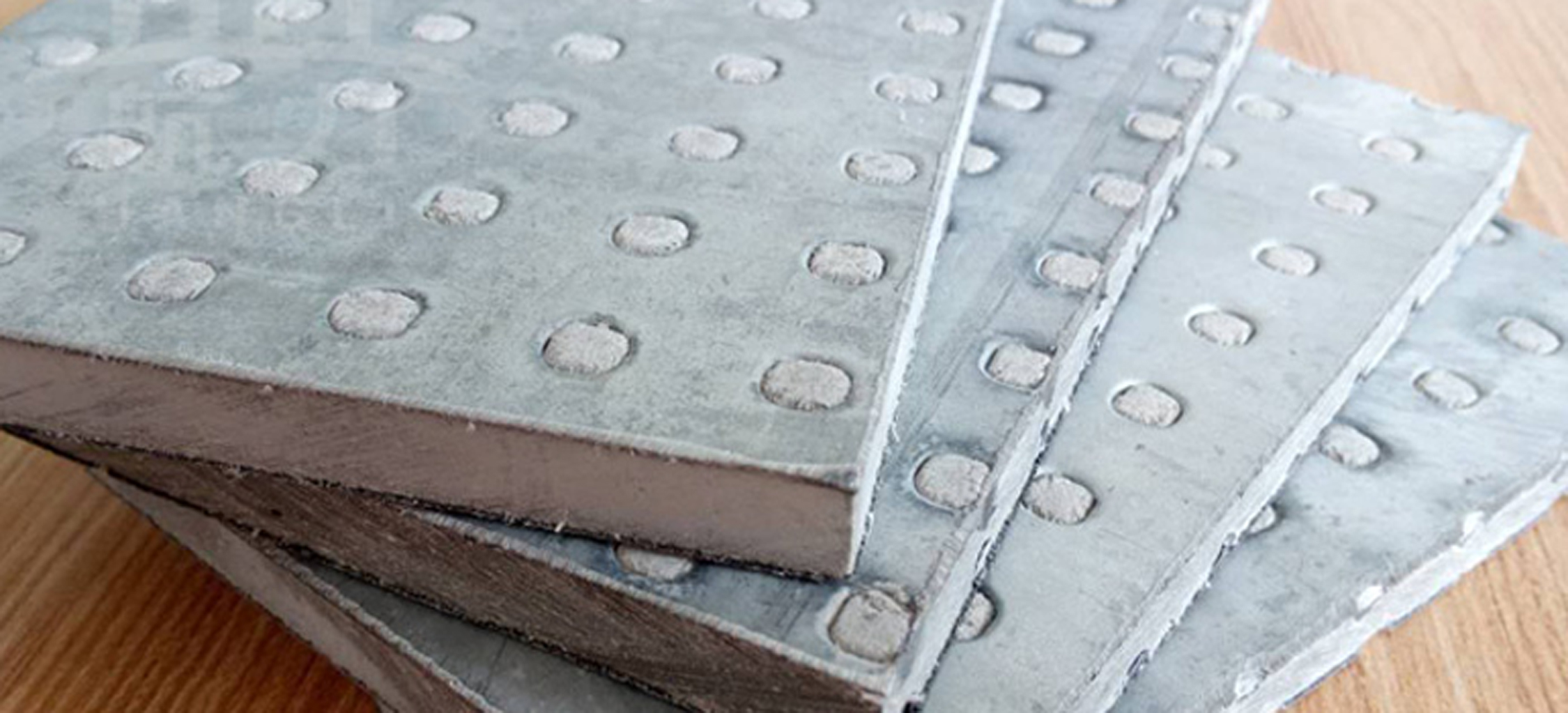 纖維水泥抗爆板又稱防爆板是為存在潛在爆炸危險(xiǎn)區(qū)域、防震等特殊工作系統(tǒng)要求提供解決方案而研發(fā)生產(chǎn)的一種特殊板材，它是由增強(qiáng)纖維水泥板表面加壓鍍鋅鋼材料所構(gòu)成，具有良好的抗爆及阻燃效果。由于板材內(nèi)部特殊的構(gòu)造可以有效減輕爆炸的沖擊，耐久性高，九德增強(qiáng)纖維水泥抗爆板依據(jù)專門爆破檢測(cè)機(jī)構(gòu)的嚴(yán)格檢測(cè)，單板抗爆能力高達(dá)1.6MPa，抗爆墻抗爆能力高達(dá)2.0MPa，遠(yuǎn)高于國(guó)家相關(guān)標(biāo)準(zhǔn)規(guī)定的墻體抗爆1.4Mpa。